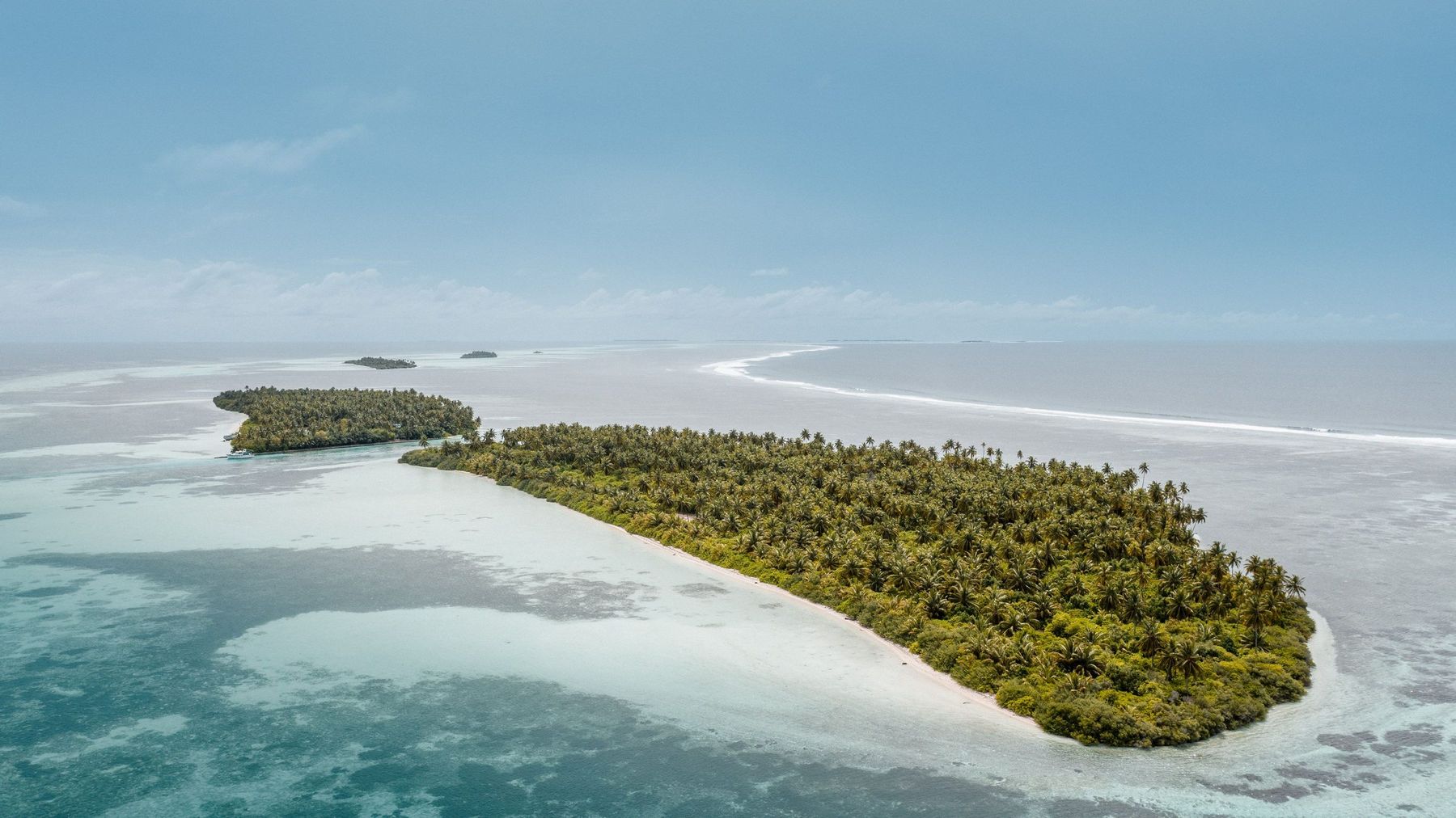 Una isla coralina baja bordeada de planicies de arena: en un atolón, la mayoría de las islas apenas se elevan unos metros sobre el mar.