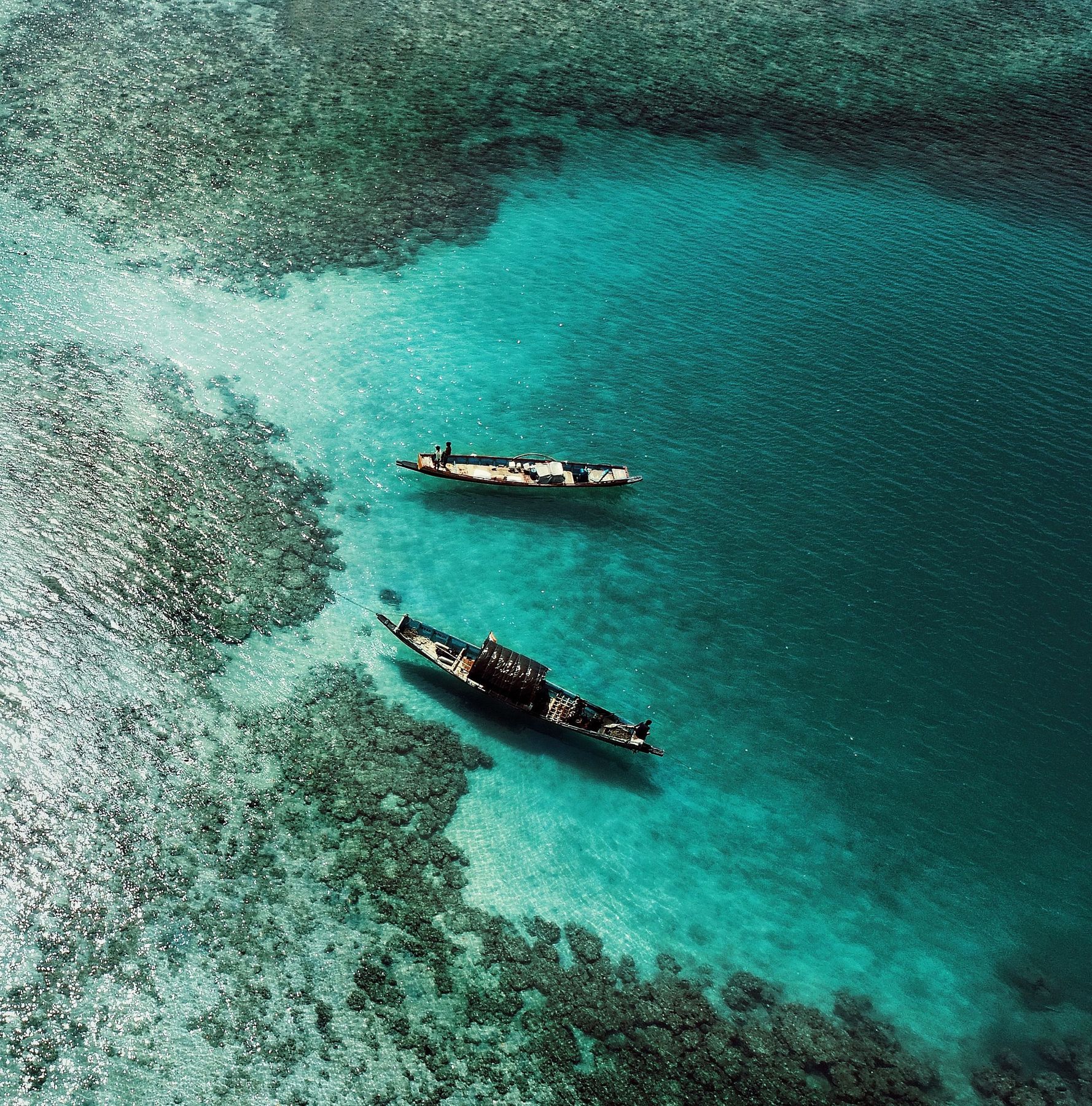 Small wooden boats over a reef flat: boats like these are how people and goods move between islands.