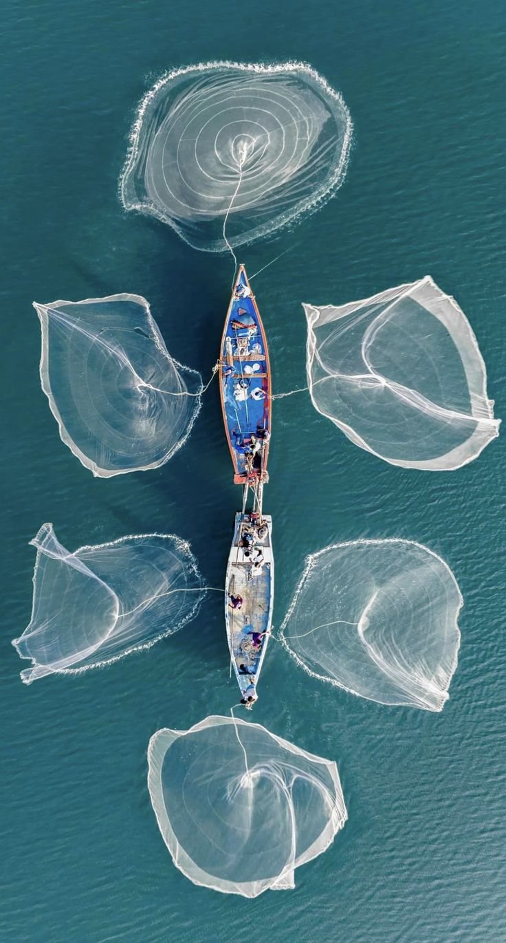 Fishing boats casting nets: fishing still shapes daily life across the islands.
